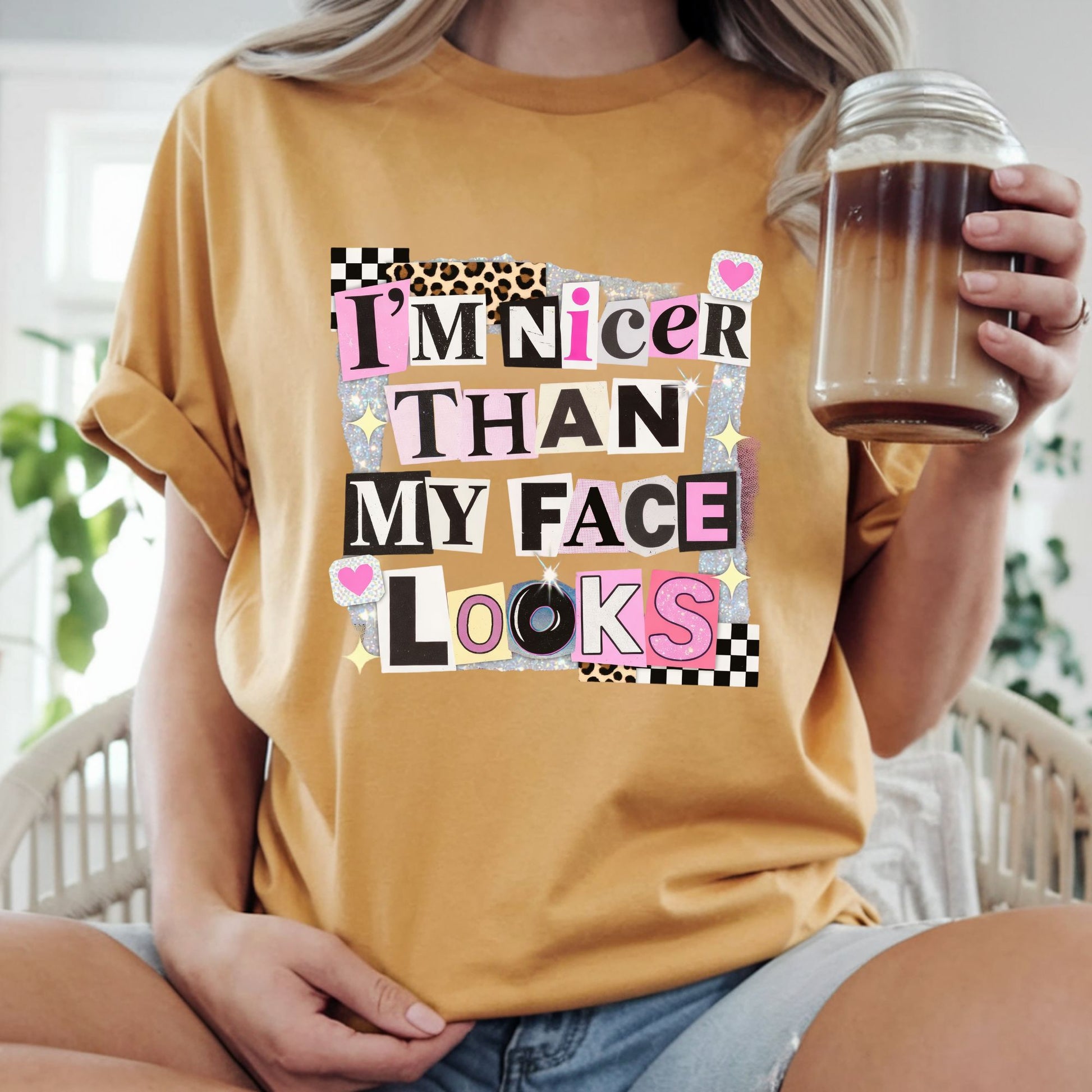 Funny graphic featuring the phrase "I'm Nicer Than My Face Looks" in a trendy ransom note collage with leopard print, checkerboard accents, glitter details, and pink aesthetic elements. Perfect for sarcastic graphic tees and hoodies.
