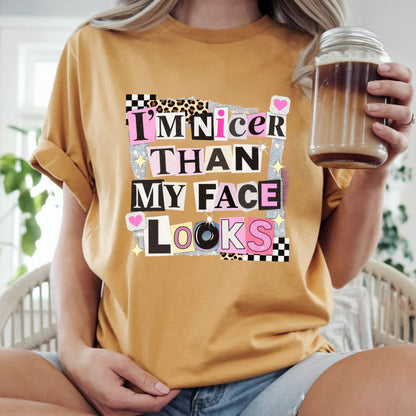 Funny graphic featuring the phrase "I'm Nicer Than My Face Looks" in a trendy ransom note collage with leopard print, checkerboard accents, glitter details, and pink aesthetic elements. Perfect for sarcastic graphic tees and hoodies.
