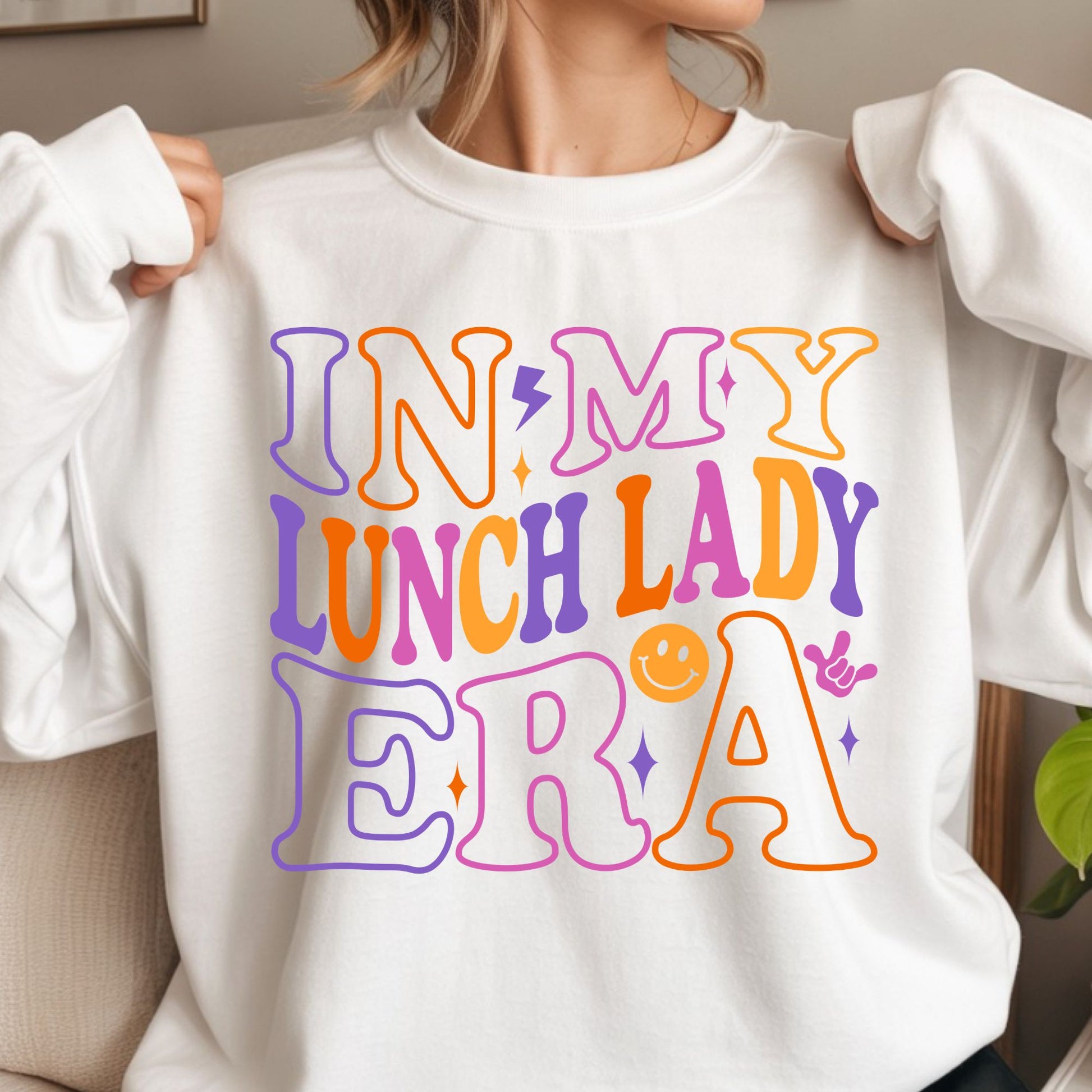 Retro In My Lunch Lady Era design featuring oversized colorful groovy typography in orange, pink, purple, and yellow with smiley face, sparkle, and hand gesture accents.