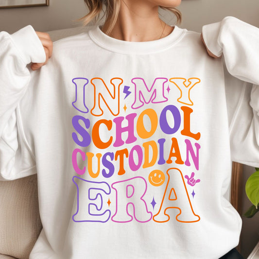 In My School Custodian Era design featuring oversized retro lettering in purple, orange, pink, and yellow with a lightning bolt, smiley face, sparkles, and playful school staff style.
