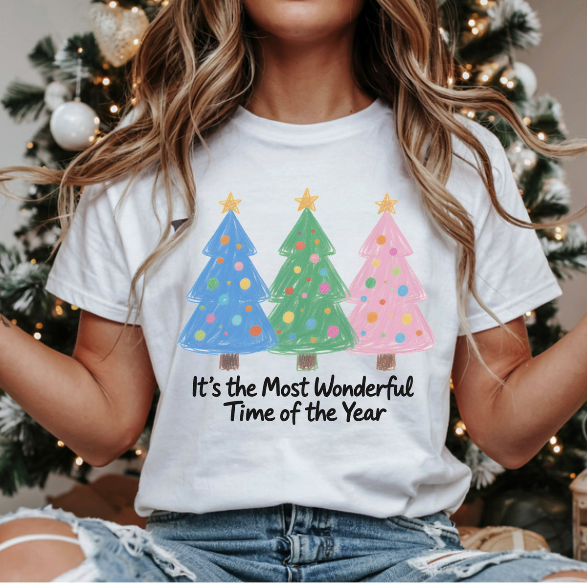Three pastel blue, green and pink Christmas trees with colorful dot ornaments and yellow stars, above “It’s the Most Wonderful Time of the Year” in black script.