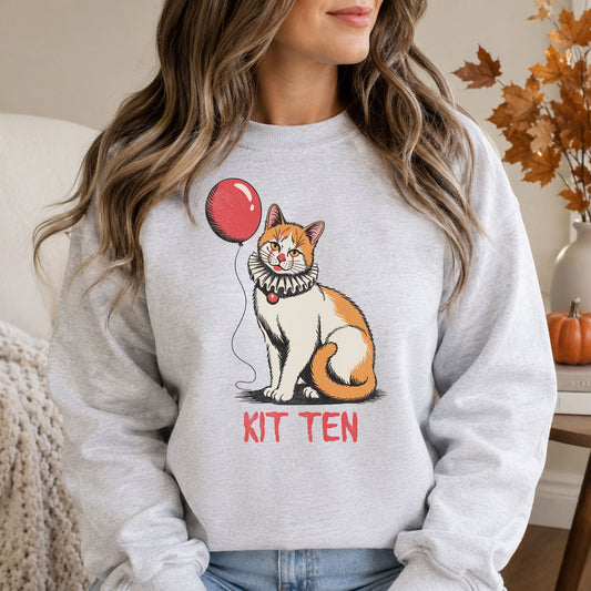 Kit Ten Halloween DTF transfer featuring an orange-and-white cat wearing a vintage ruffled clown collar while holding a red balloon, with distressed red lettering on a light gray sweatshirt mockup.