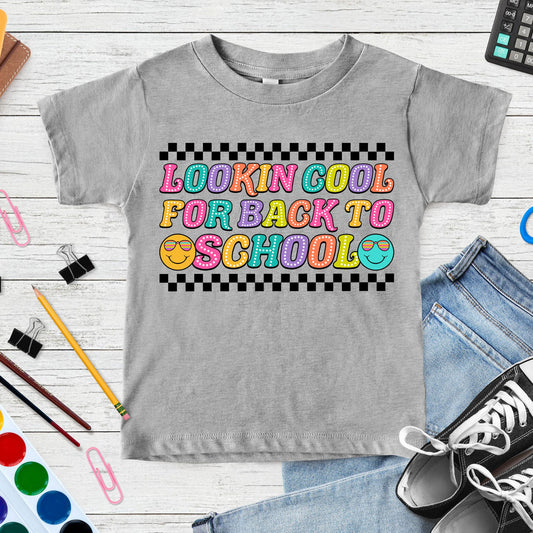 Lookin’ Cool for Back to School design featuring colorful retro bubble letters, two sunglasses smiley faces, and bold black checkerboard accents for toddler, kids, and youth shirts.