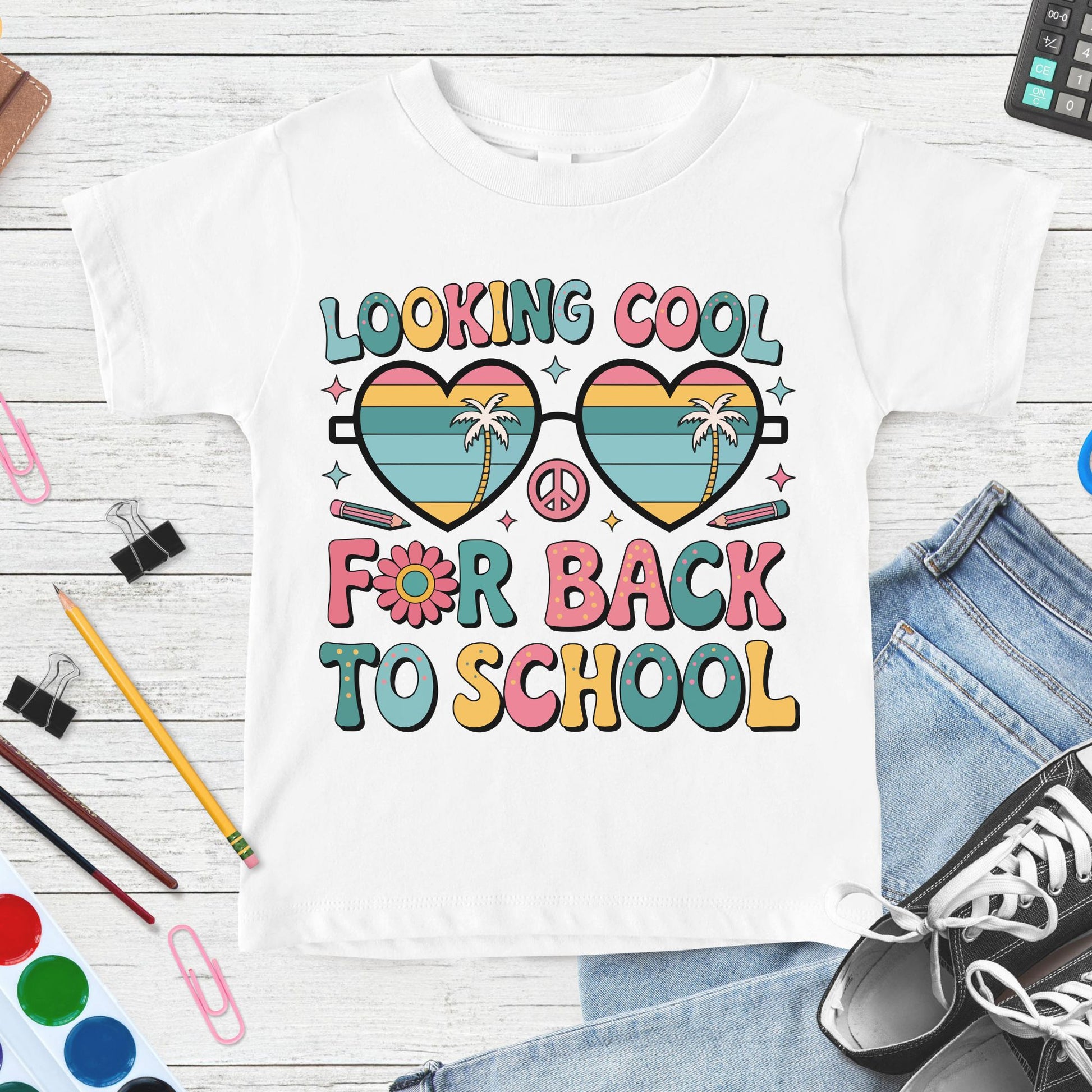 Looking Cool for Back to School design featuring retro heart-shaped sunglasses, palm trees, peace sign, pencils, flower accents, and colorful groovy lettering for kids shirts.