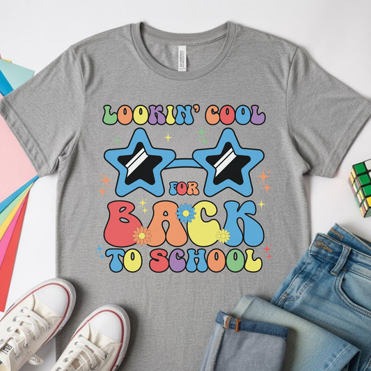Lookin’ Cool for Back to School design featuring blue star-shaped sunglasses, colorful retro lettering, flowers, and sparkles for toddler, kids, and youth shirts.