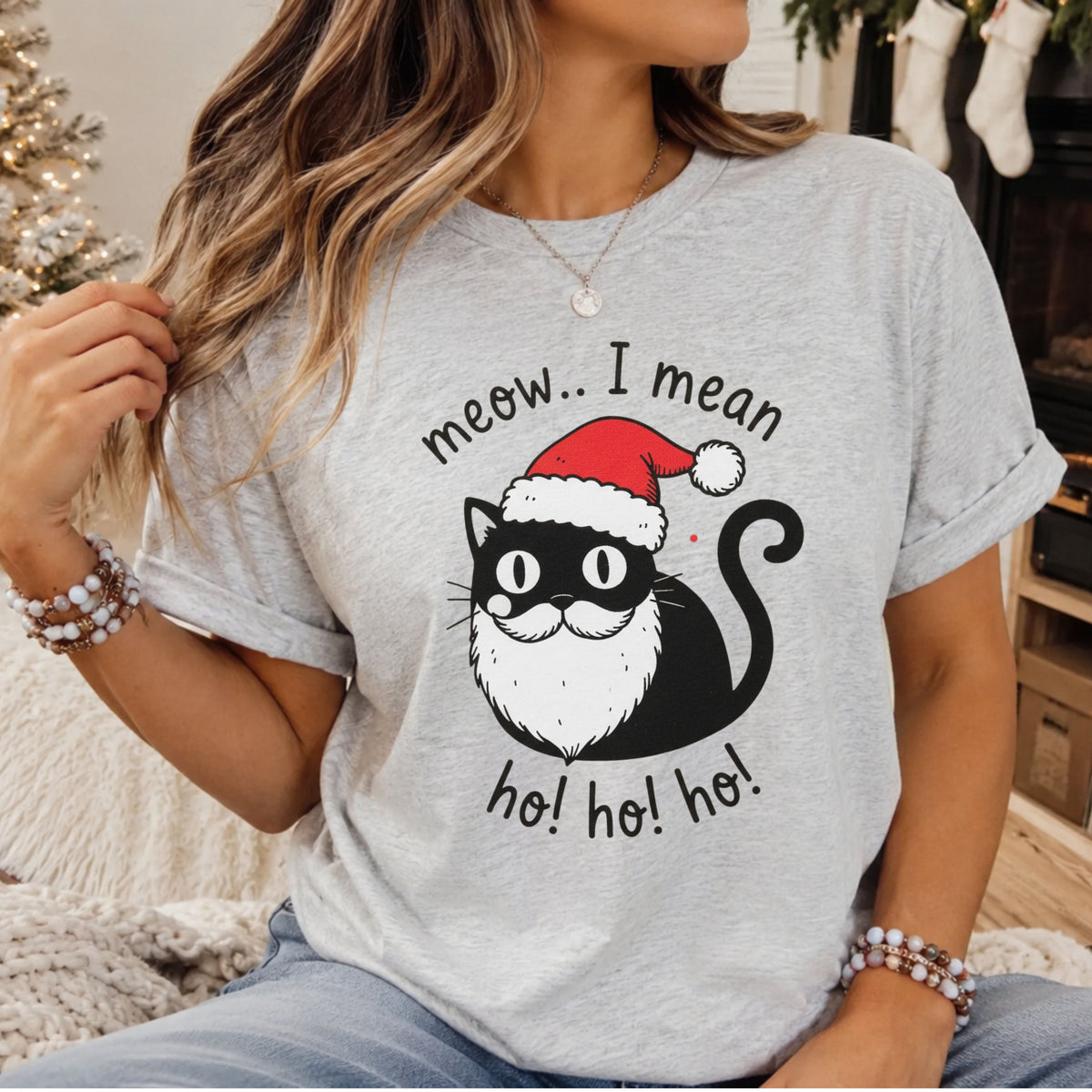 Black cat with a curled tail wearing a red Santa hat and white beard, surrounded by “Meow… I mean ho! ho! ho!” lettering.