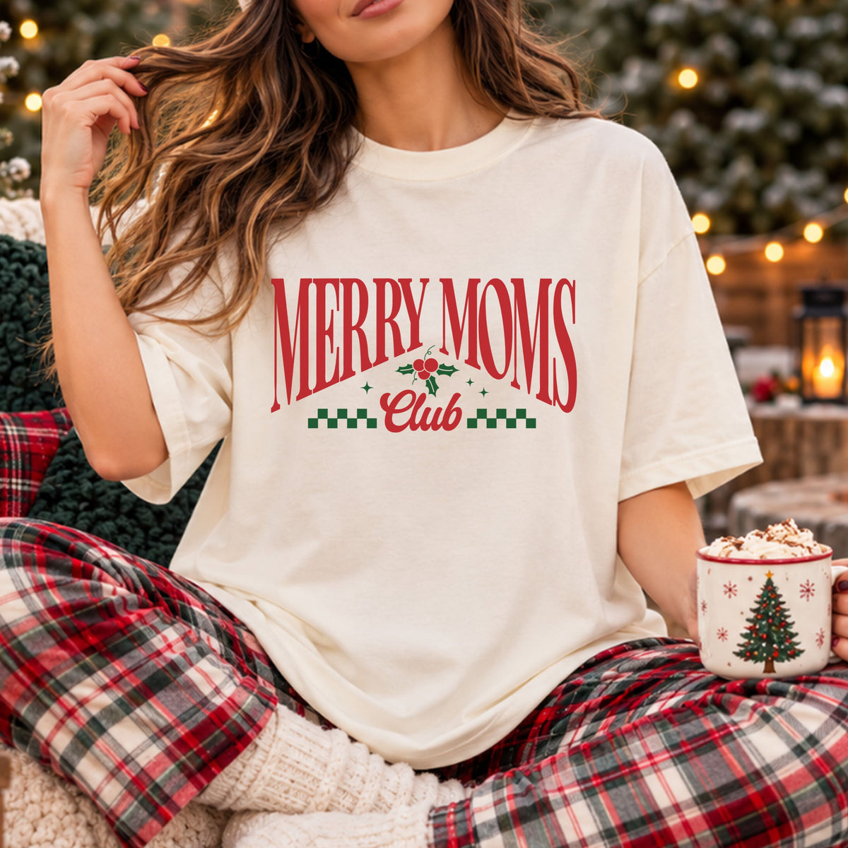“Merry Moms” in arched red serif letters above “Club” in red script, accented with holly, red berries, green sparkles and green checkered trim.