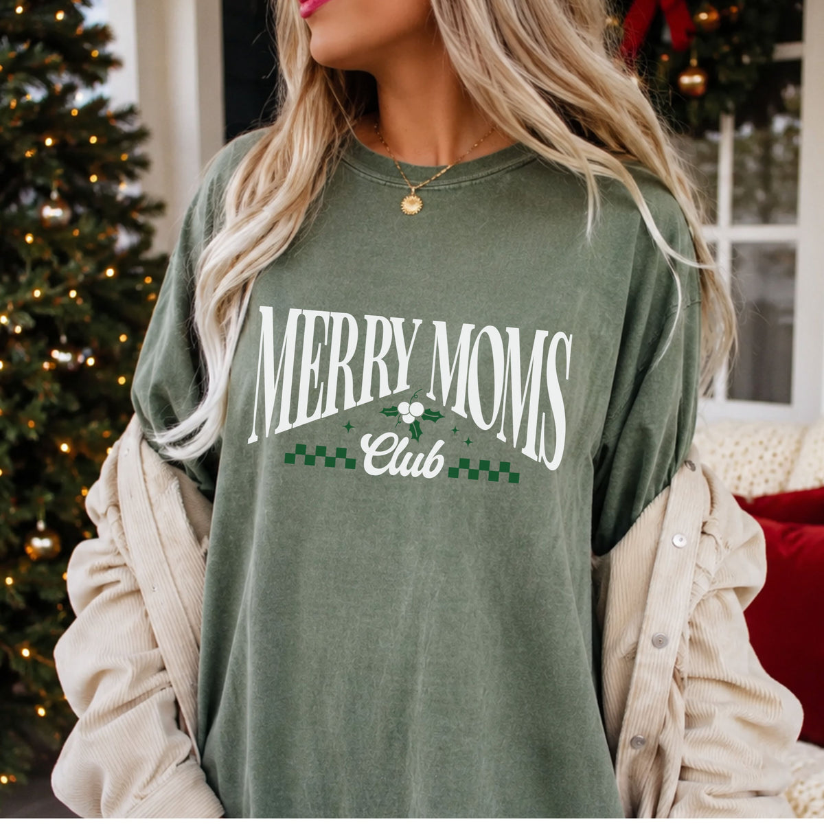 “Merry Moms” in arched white serif letters above “Club” in white script, accented with green holly, white berries, green sparkles and green checkered trim.