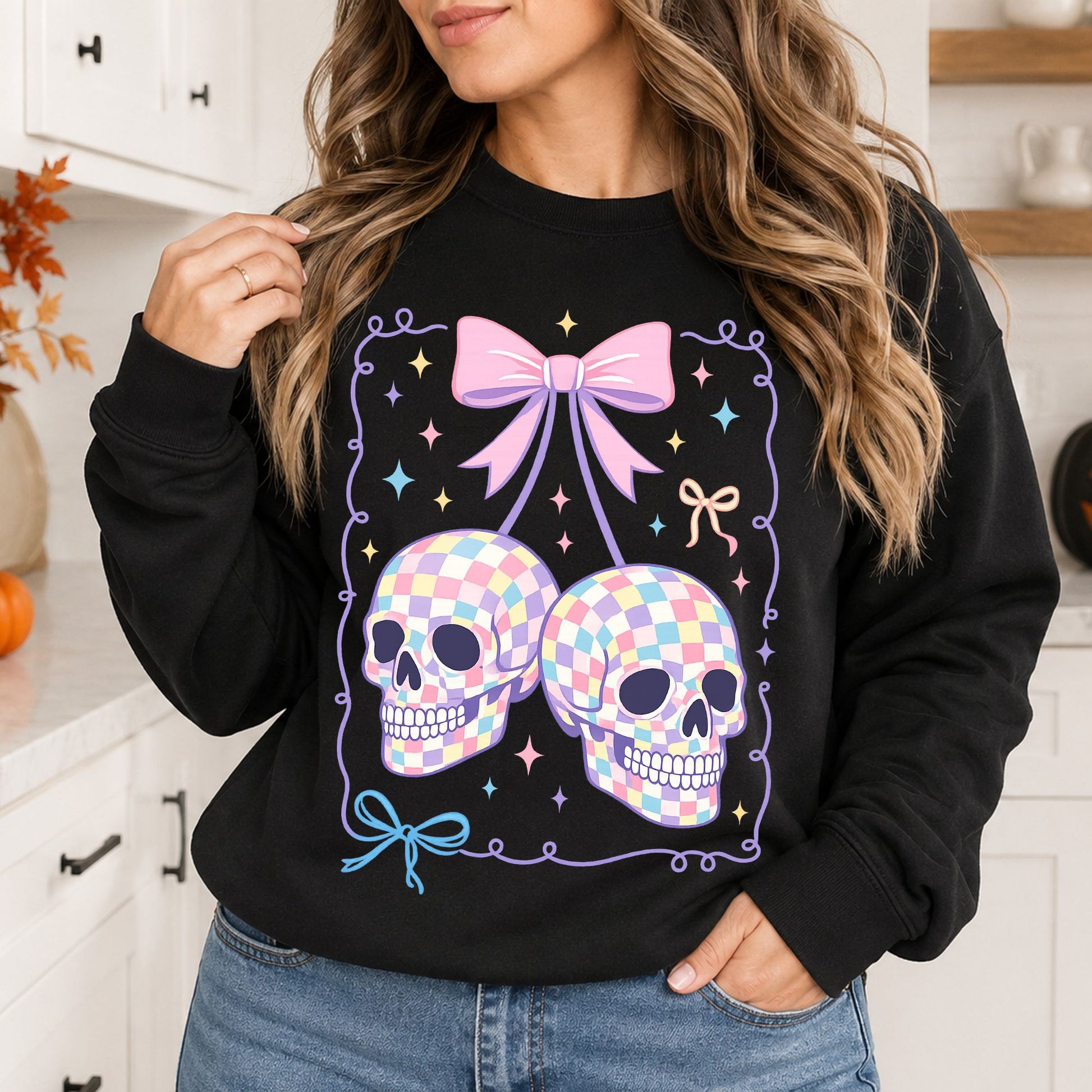 Black sweatshirt mockup featuring two pastel checkered skull cherries, a pink bow, colorful sparkles, and coquette Halloween details.
