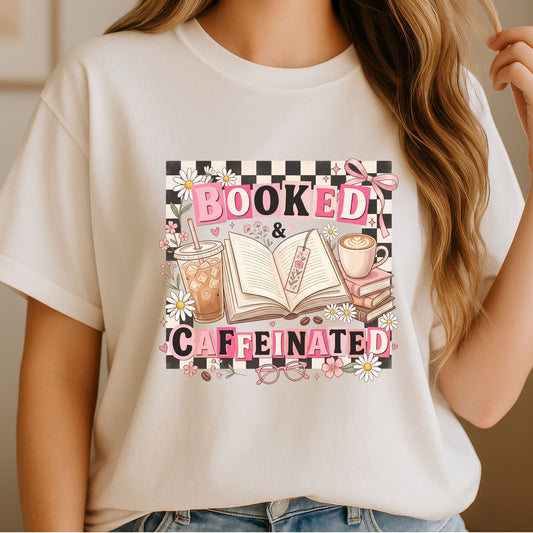 Booked & Caffeinated DTF transfer featuring pink retro lettering, black and white checkerboard, open books, iced coffee, hot coffee, daisies, flowers, glasses, and a pink bow for book lover shirts, reader sweatshirts, and bookish apparel.