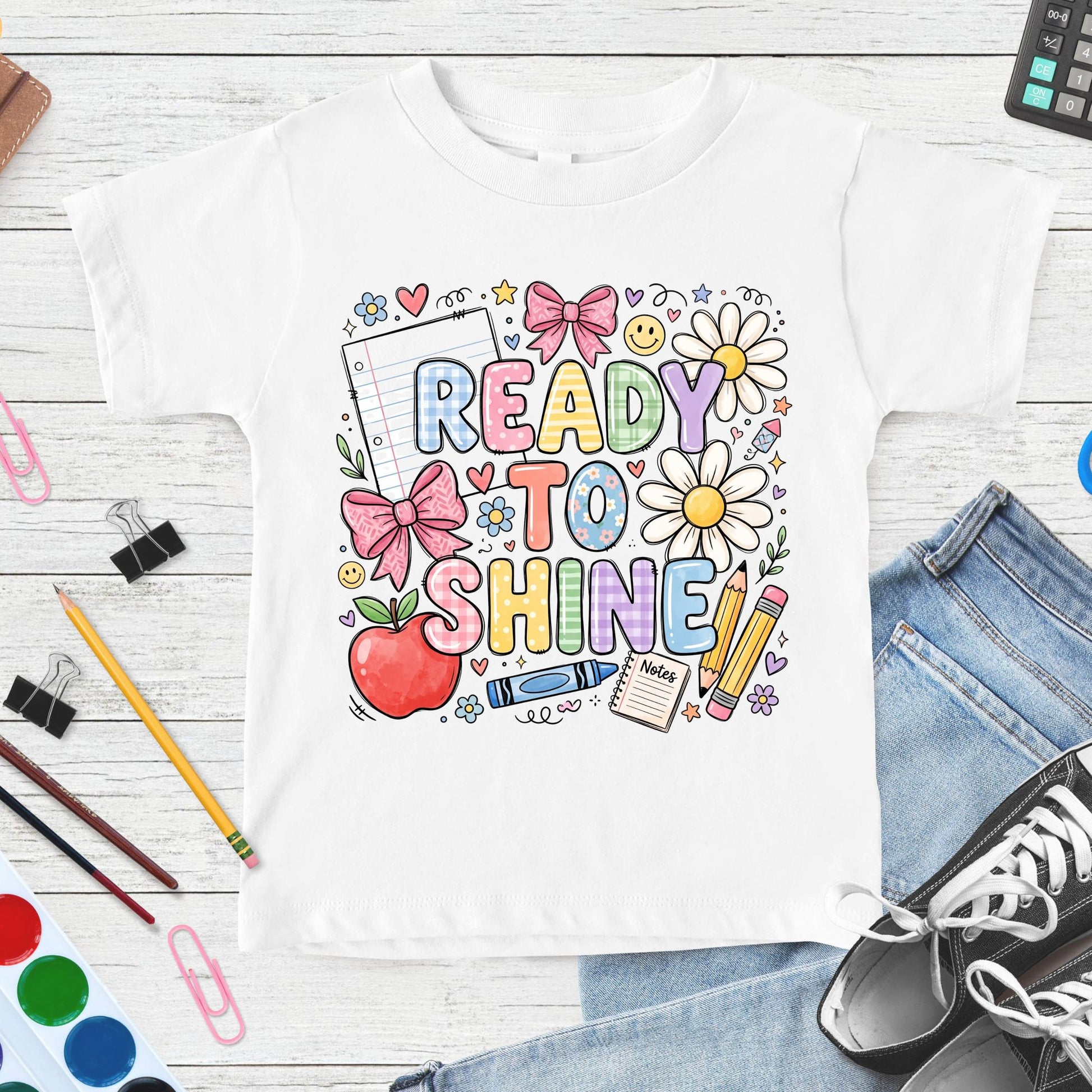 Ready to Shine back-to-school design featuring colorful plaid lettering, pink bows, daisies, apple, crayons, pencils, notebook paper, hearts, and cheerful classroom doodles.