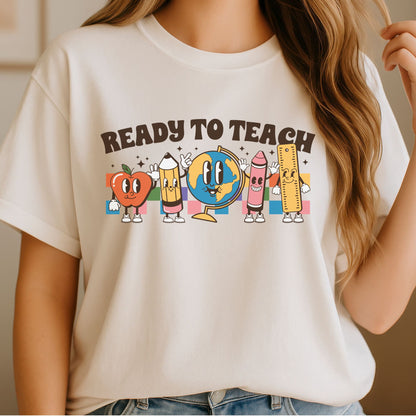 Cute Ready to Teach teacher design featuring smiling school supplies including an apple, globe, pencil, crayon, ruler, and colorful retro classroom graphics perfect for teachers and back-to-school apparel.
