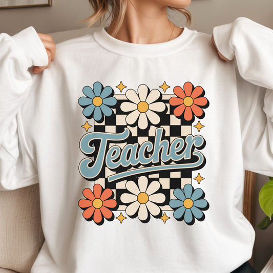 Retro floral Teacher DTF transfer featuring blue, cream, and orange daisies with a black checkerboard background and vintage script lettering.