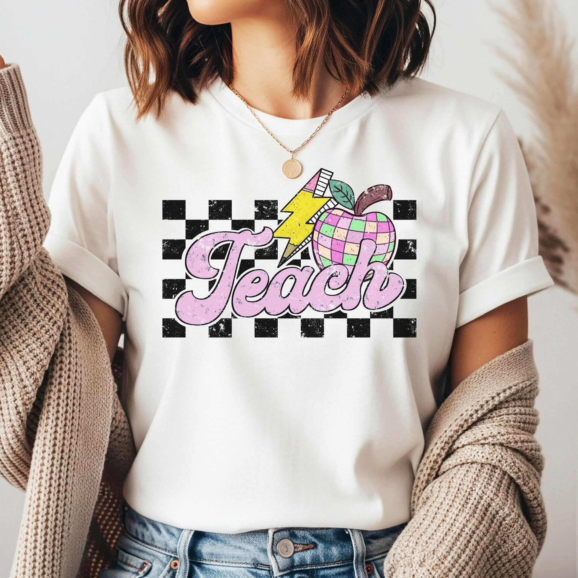 Retro Teach design featuring distressed pink lettering with a pastel checkerboard apple, yellow lightning bolt, pencil, and black checkerboard background for teacher shirts, hoodies, sweatshirts, tees, and ready-to-press DTF transfers.