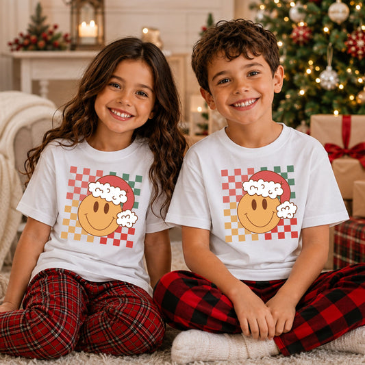Yellow smiley face wearing a red and white Santa hat over a distressed checkerboard pattern in coral pink, sage green, mustard yellow and red.
