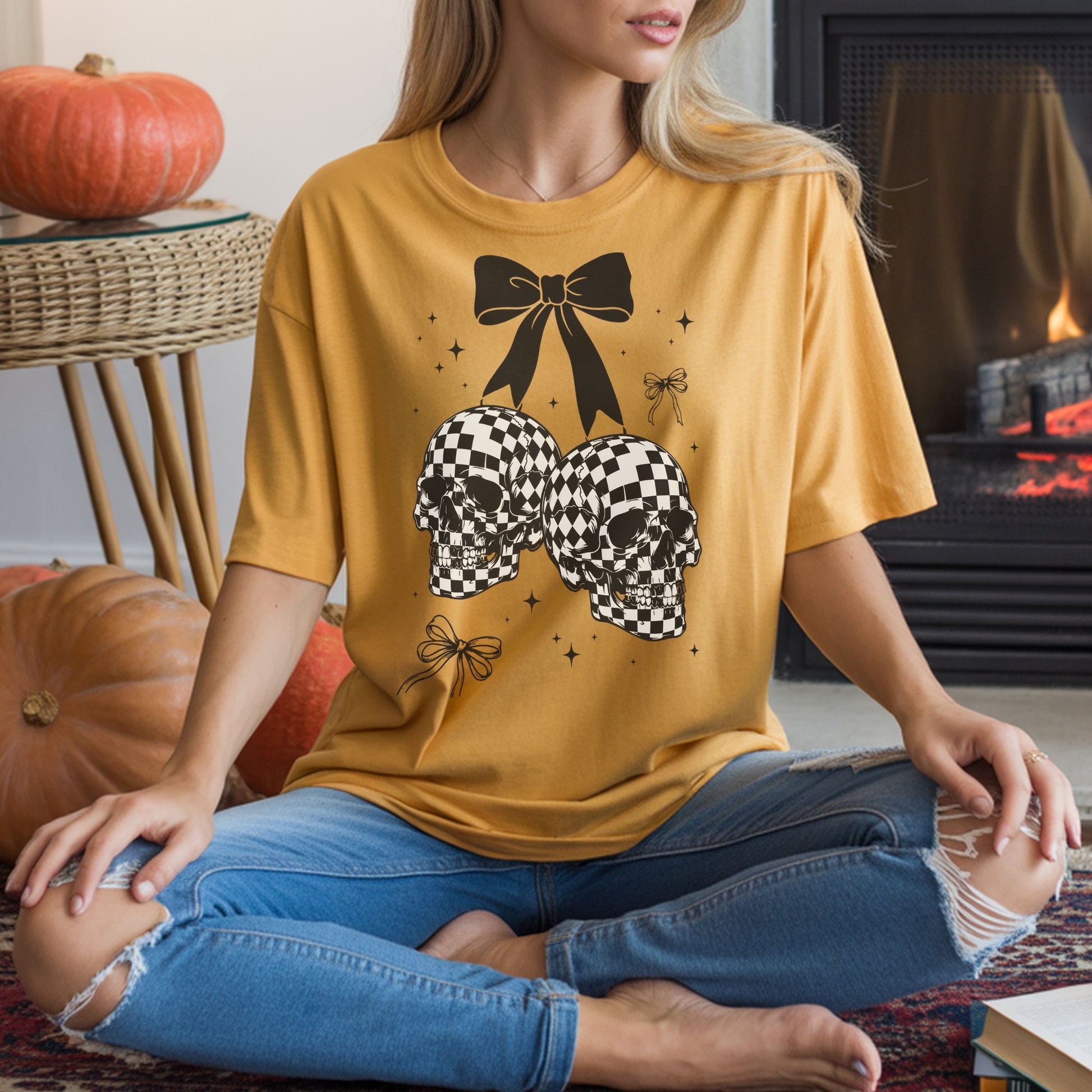 Mustard yellow T-shirt mockup featuring checkered skull cherries with a black bow and coquette spooky details in a Halloween design.
