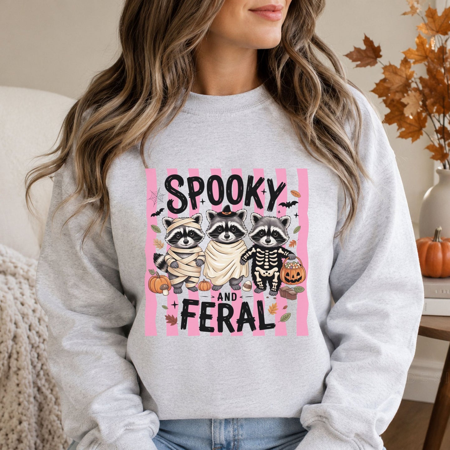 Black sweatshirt mockup featuring a coquette Halloween goose flying on a broom with a witch hat, pink bows, bats, and the phrase Spooky Goosey.