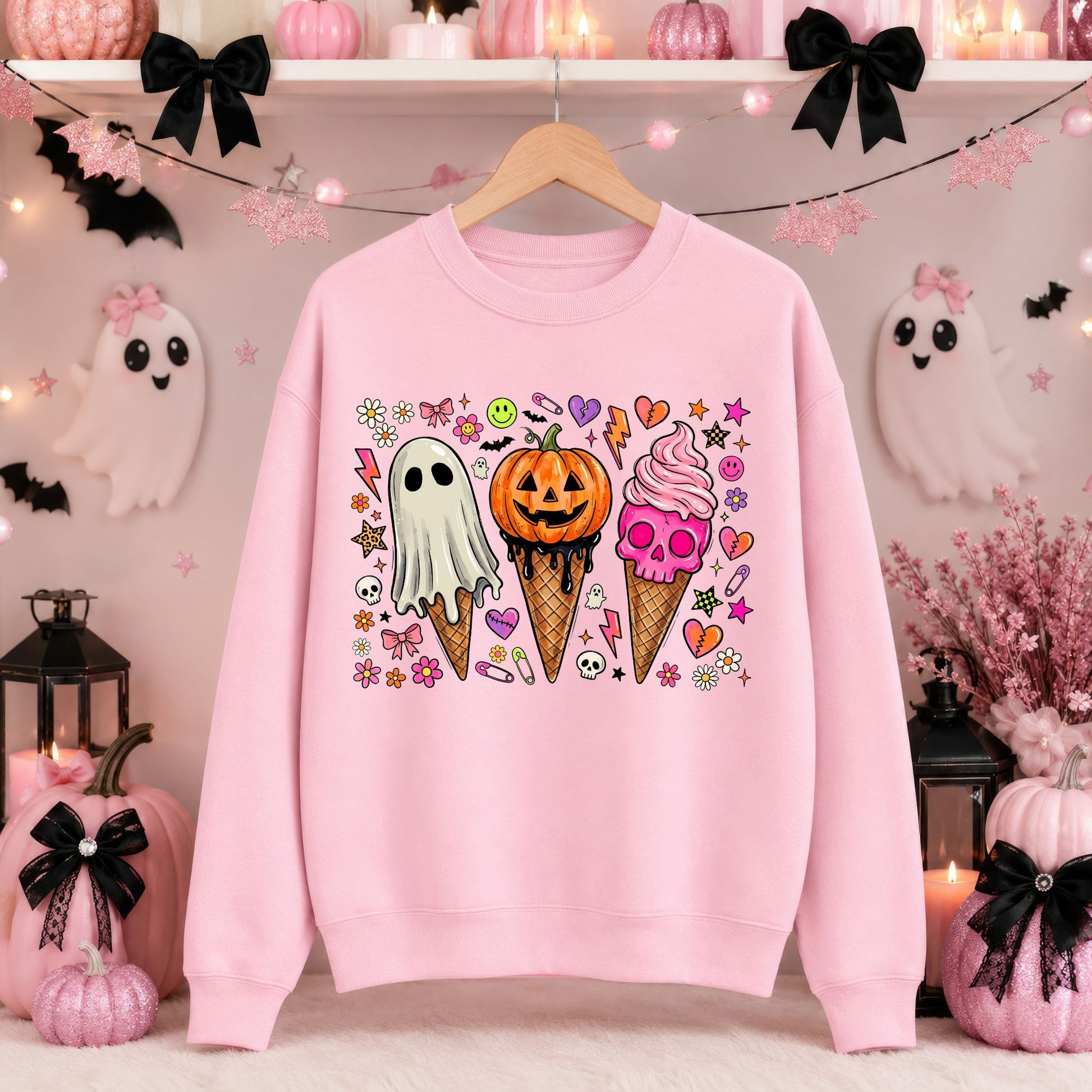 Spooky Halloween DTF transfer featuring three ice cream cones topped with a dripping sheet ghost, jack-o’-lantern pumpkin and pink skull soft serve, surrounded by colorful flowers, hearts, stars, lightning bolts, safety pins and tiny spooky icons on a pink sweatshirt mockup.