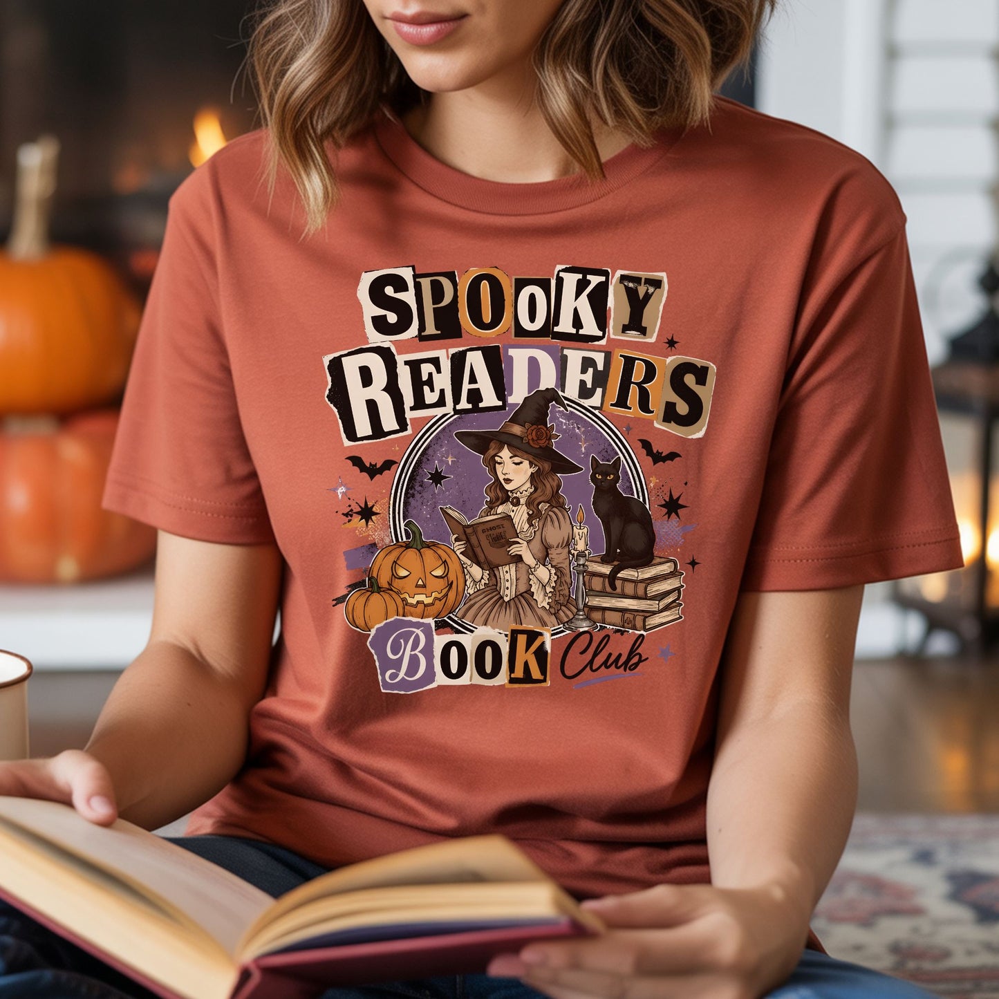 Rust-colored T-shirt mockup featuring a spooky readers book club design with a witch reading, a black cat, pumpkins, books, and Halloween details.
