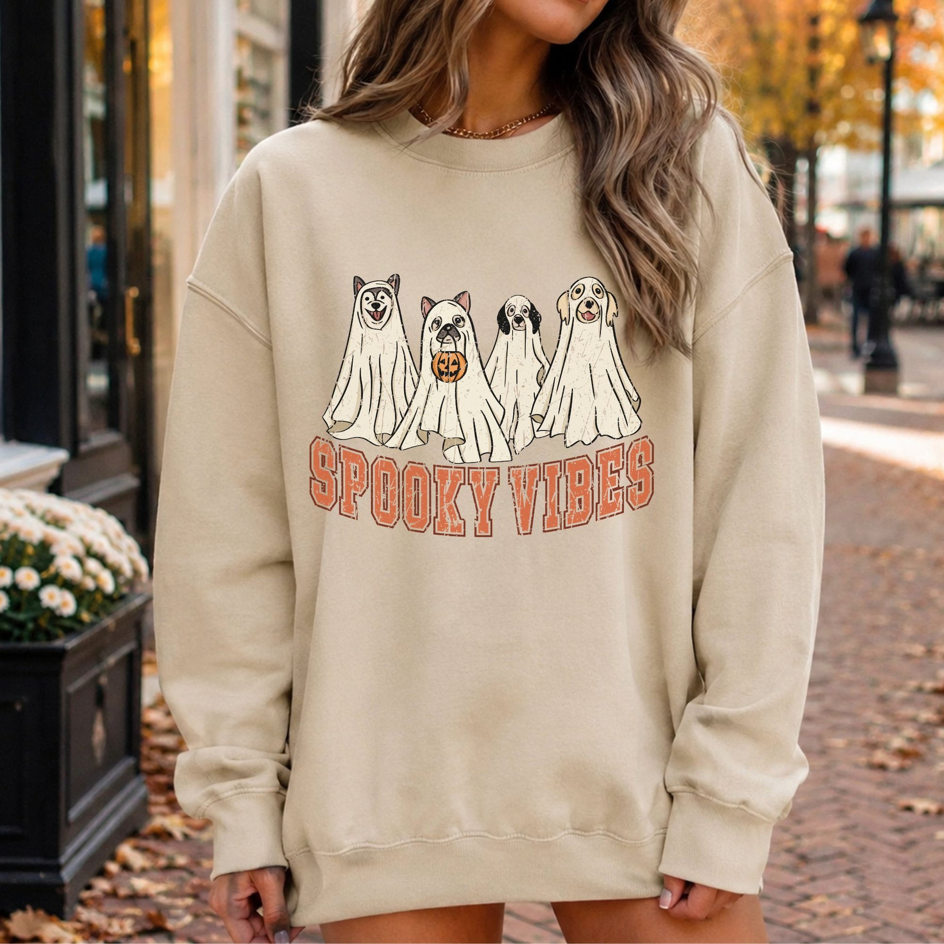 Sand crewneck mockup featuring four dog ghosts with the phrase Spooky Vibes in a retro Halloween design.