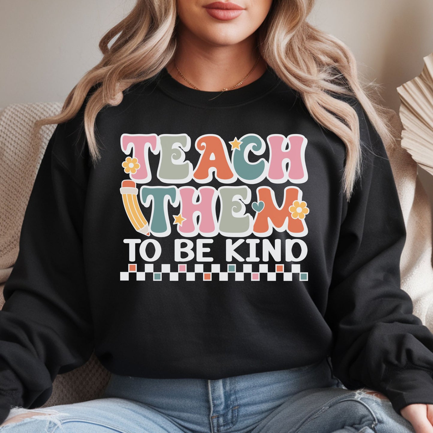 Teach Them to Be Kind teacher design featuring retro pastel lettering, a yellow pencil, small flowers, hearts, stars, and a black-and-white checkerboard accent.