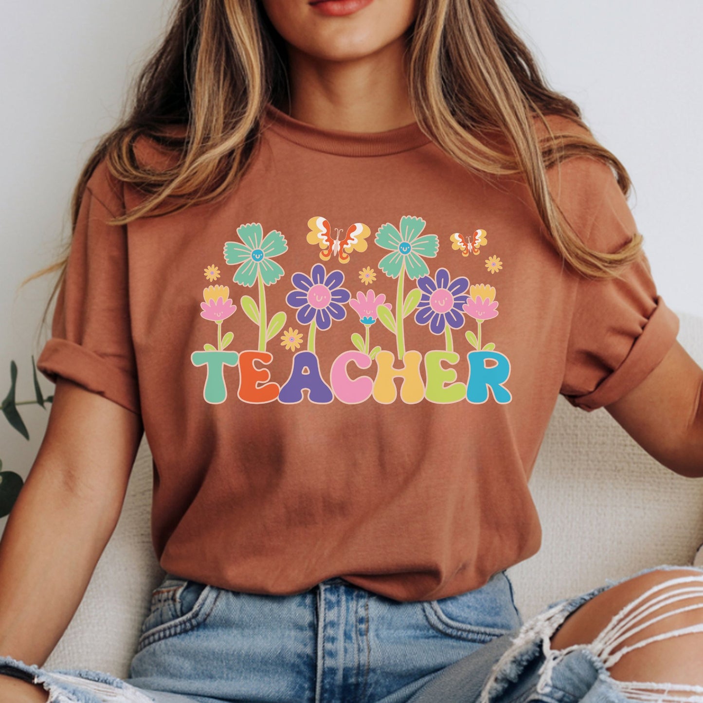 Colorful floral Teacher design featuring smiling retro flowers, playful butterflies, bright multicolor lettering, and cheerful classroom style for teacher shirts, sweatshirts, hoodies, and ready-to-press DTF transfers.