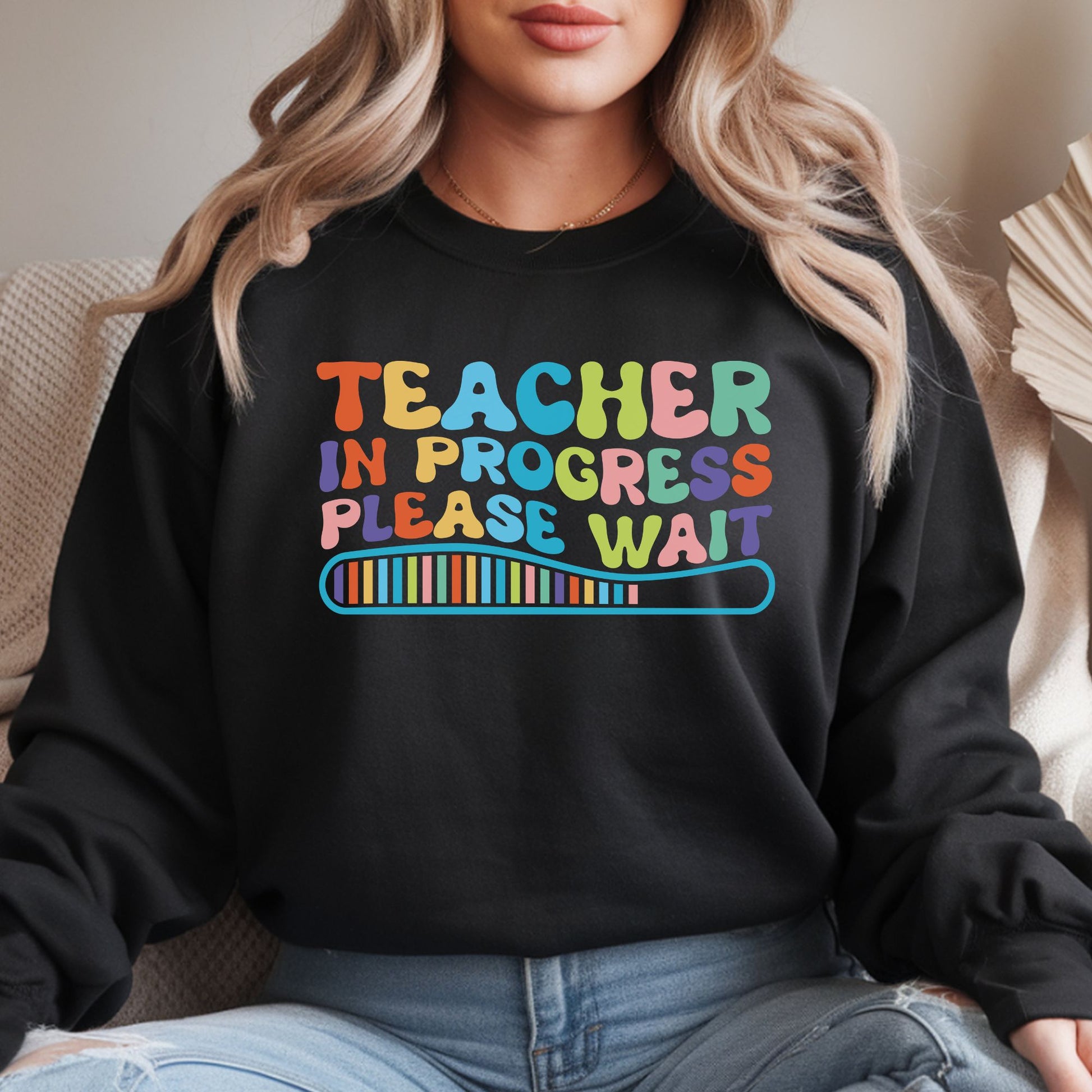 Teacher in Progress Please Wait DTF transfer featuring colorful retro lettering and a loading bar graphic on a black sweatshirt mockup.