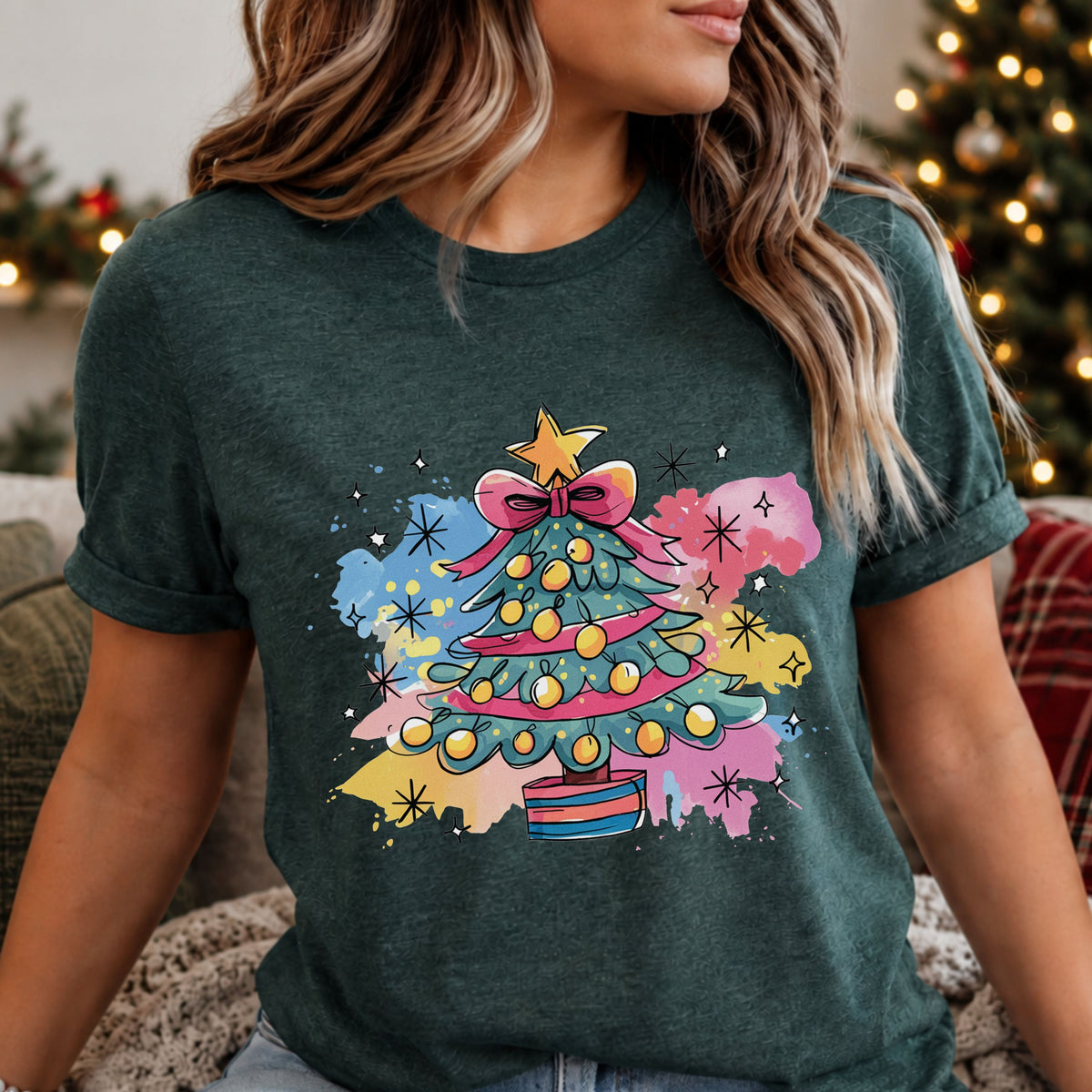 Teal Christmas tree with a pink bow, ribbon garland, yellow ornaments and striped pot, surrounded by pink, blue and yellow watercolor splashes and black starbursts.