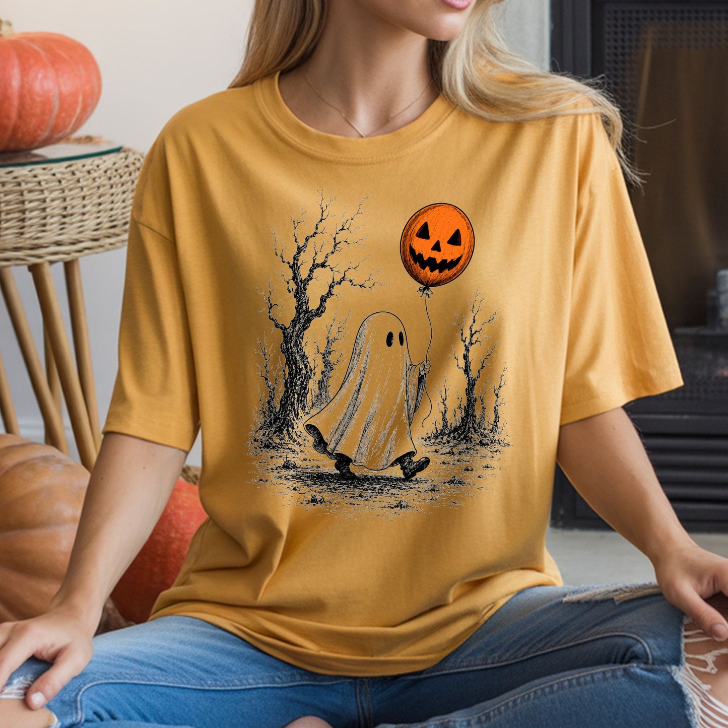Vintage Halloween DTF transfer featuring a sheet ghost walking through a spooky forest of bare trees while holding an orange jack-o’-lantern balloon, illustrated with distressed black sketch details on a mustard yellow T-shirt mockup.