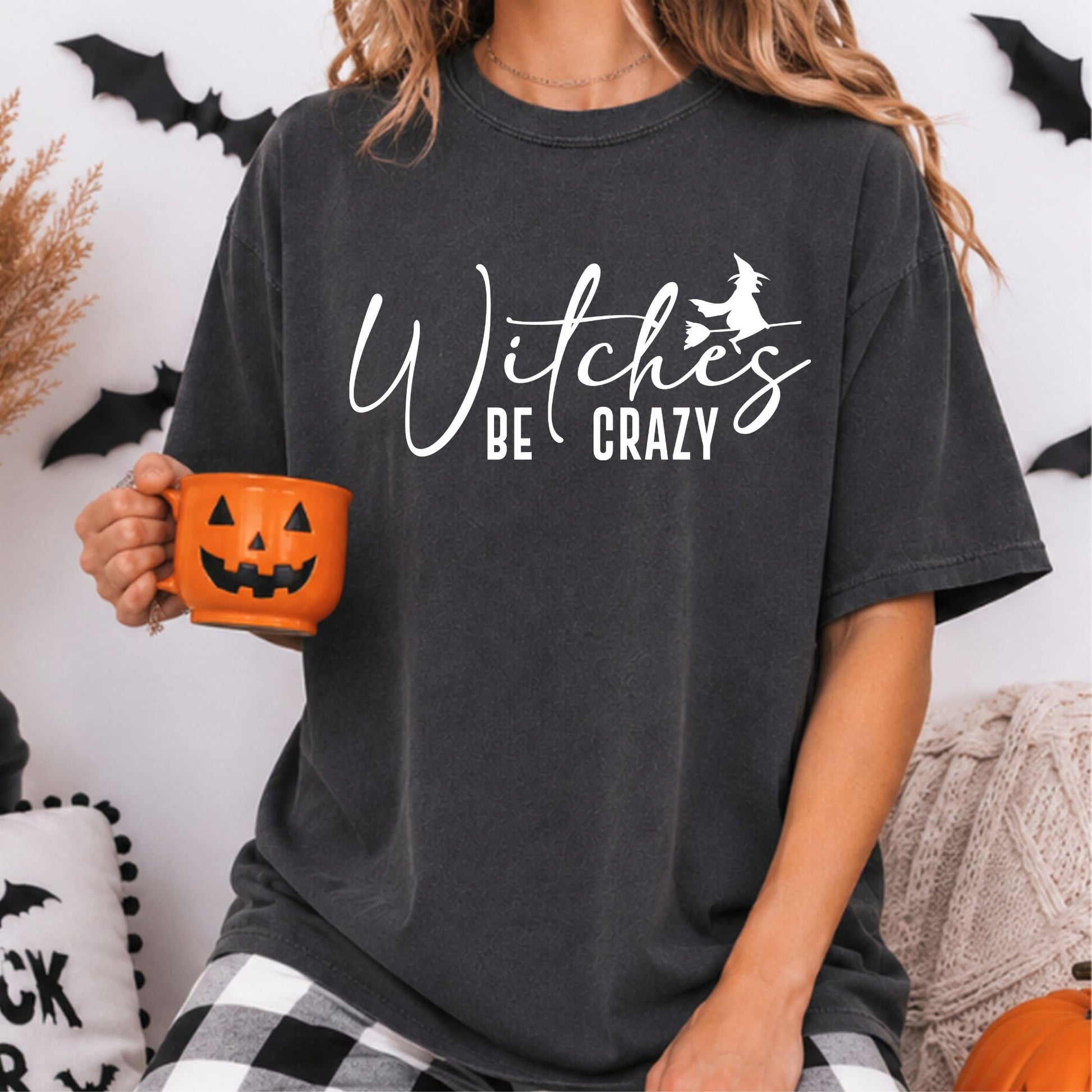 Witches Be Crazy Halloween DTF transfer featuring elegant white script lettering with a flying witch silhouette riding a broom on a dark charcoal T-shirt mockup.